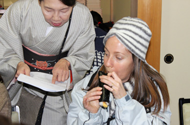 外国人に恵方巻きの食べ方を教える「老舗料亭　女将」の写真
